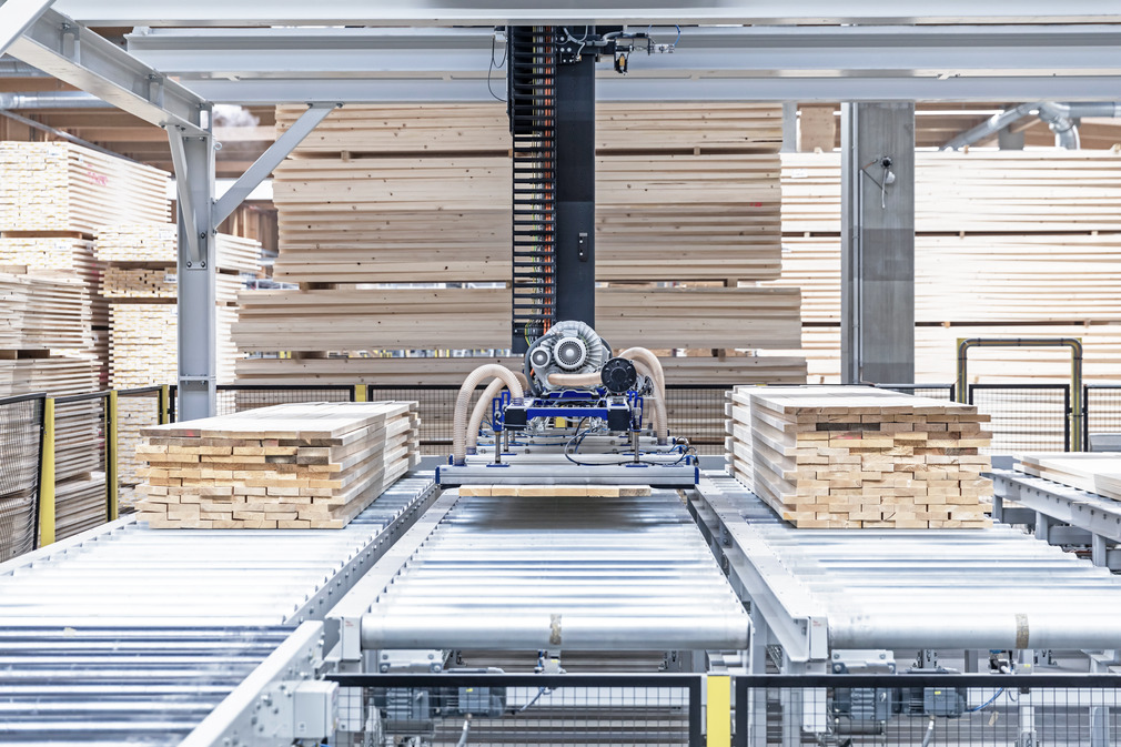 The suction spider SSP lifts the parallel lying boards and stacks them slightly offset on four goods stacks.